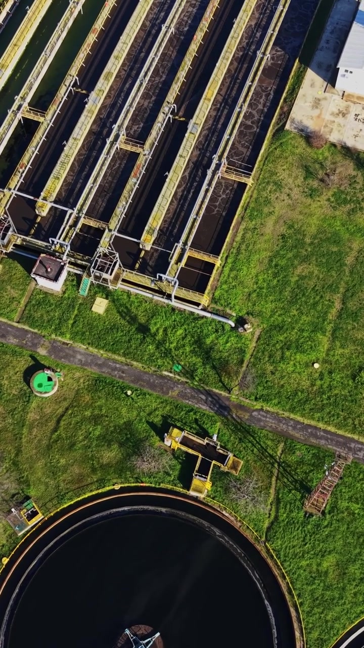 Water treatment facility with large tanks and green landscape
