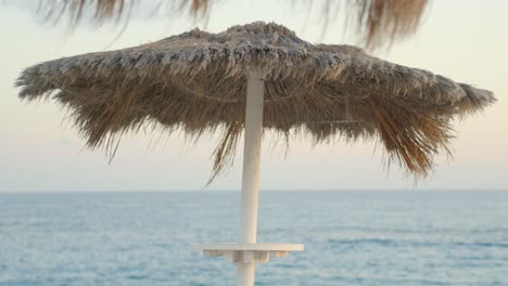 straw beach umbrella and atlantic ocean in tenerife island