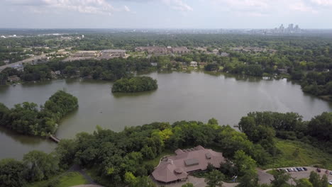 Aerial-view-rising-above-lake-with-Minneapolis-skyline-in-the-distance