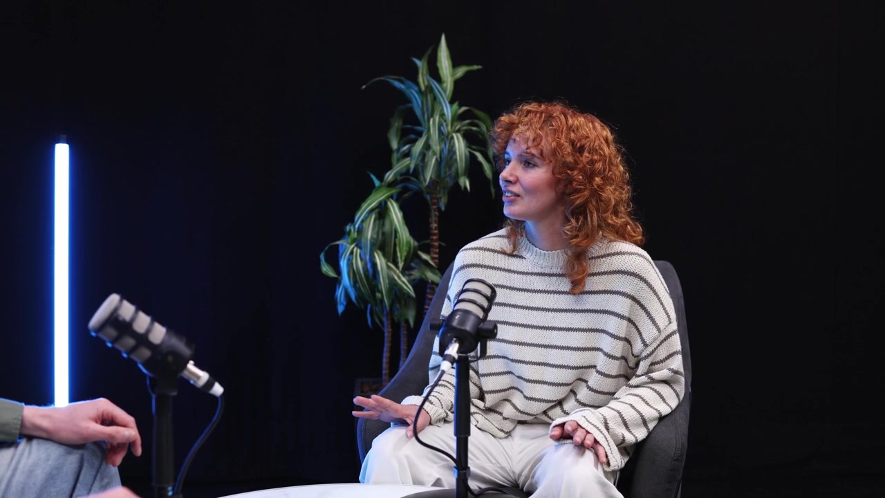 Giovane donna dai capelli rossi impegnata in un'intervista podcast.