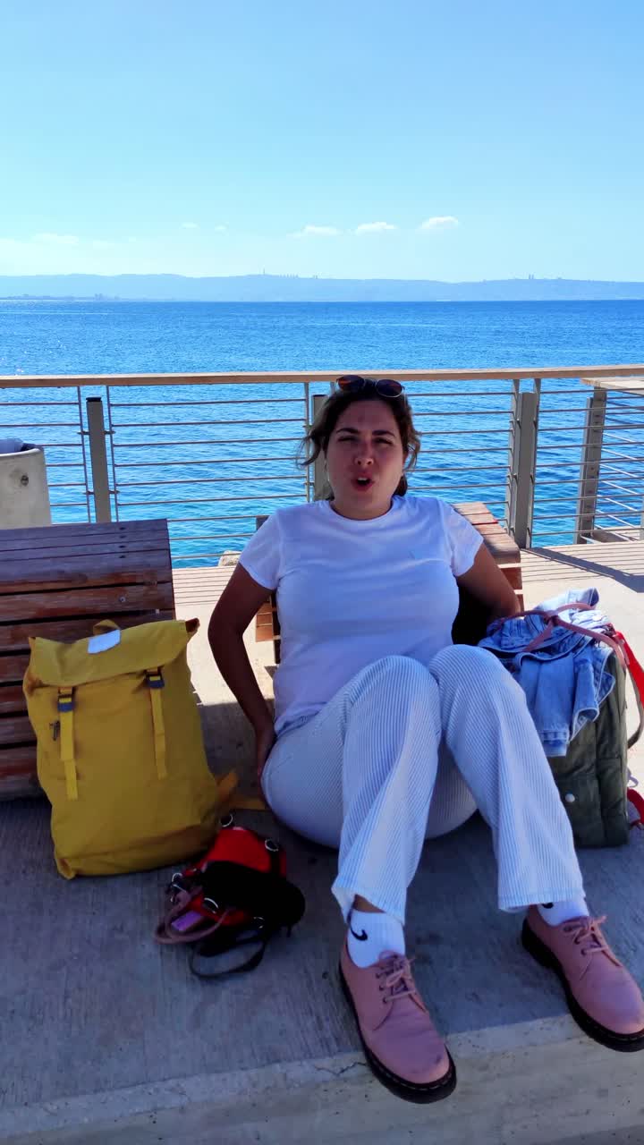 Expressive young woman sitting on a bench talking during her travels