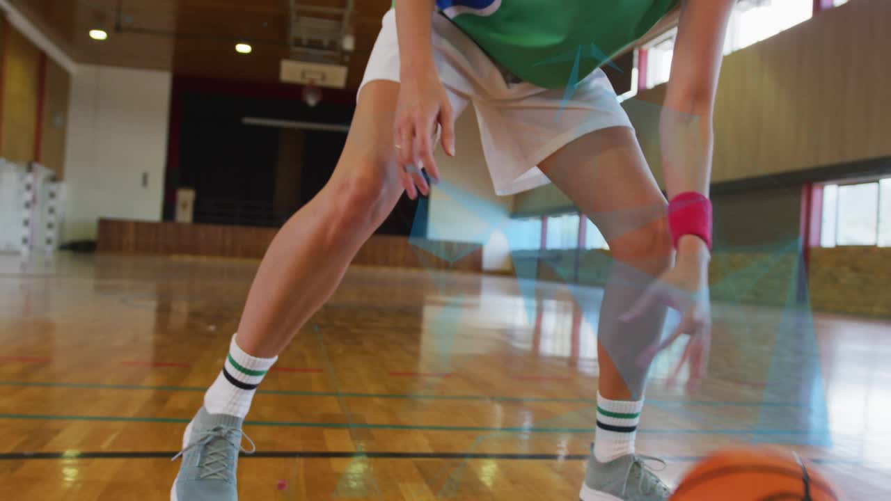 Female basketball player starting drill, dribbling between legs while shifting stance for training