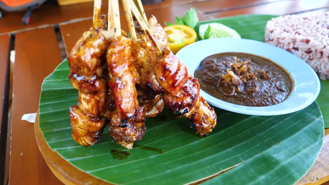 Kana satay, kastike ja riisi sydämenmuotoisena tarjoiltuna pöydällä