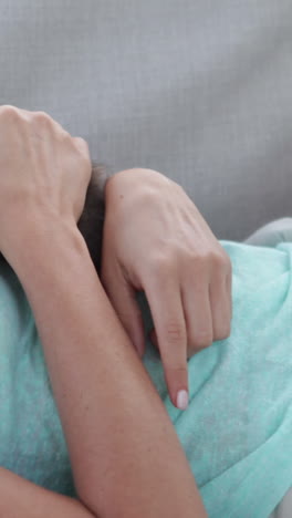 mujer sonriente acostada en el sofá jugando con un gatito diminuto