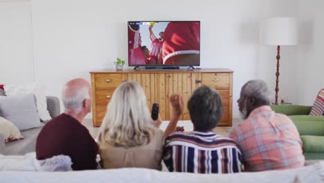 Video-Einer-Gruppe-älterer-Menschen,-Die-Auf-Der-Couch-Sitzen-Und-Sich-Ein-Fußballspiel-Ansehen