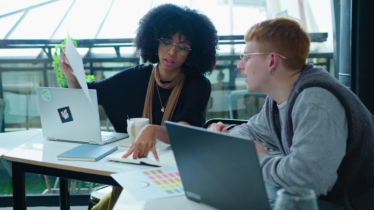 Young Coworkers Making Notes and Discussing Business Ideas in the Office