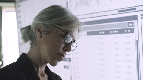 closeup female manager studying charts on big screen