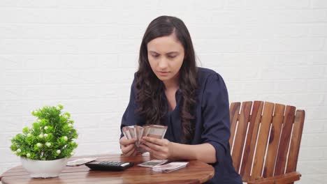 ama de casa india contando dinero para el presupuesto