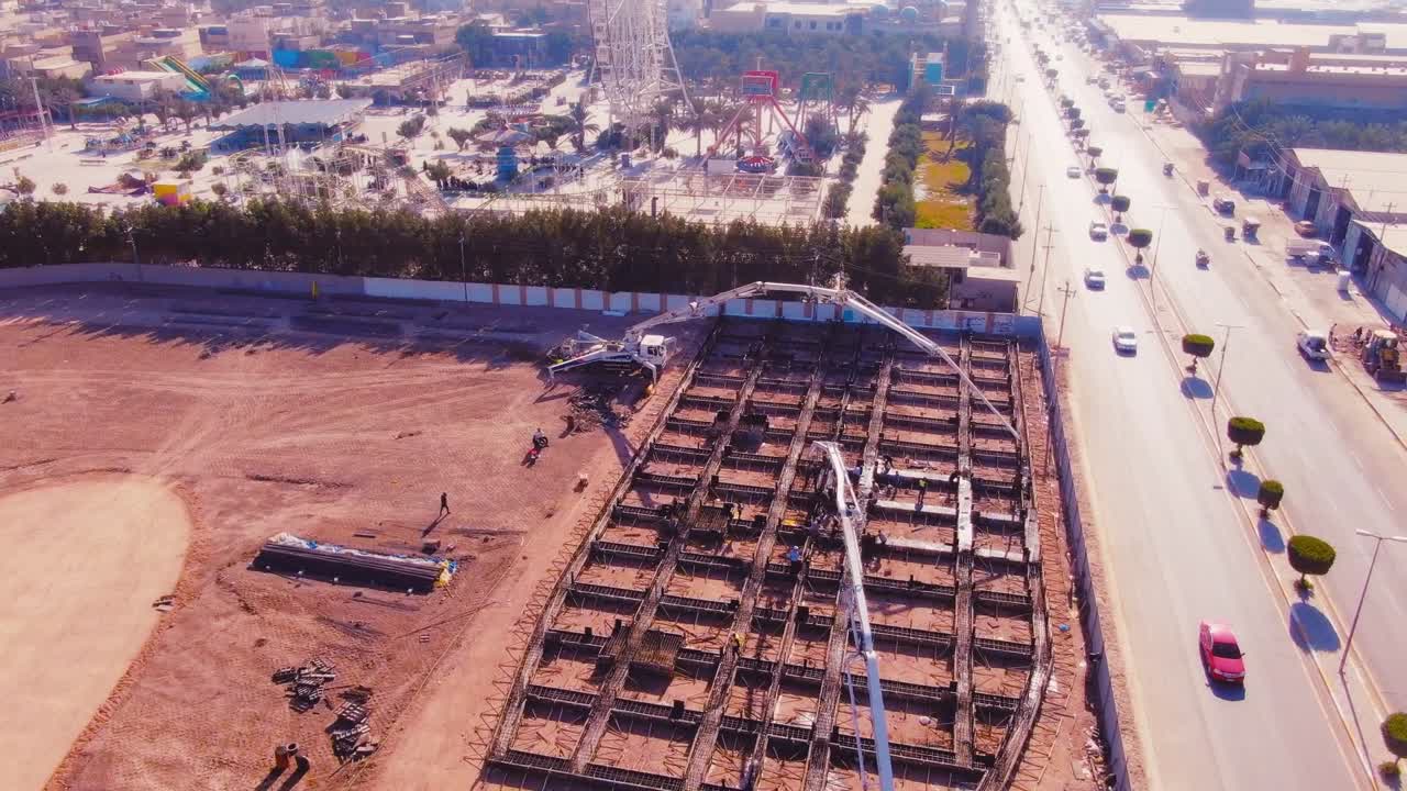drone shot, construction area with builders working during the day pouring concrete