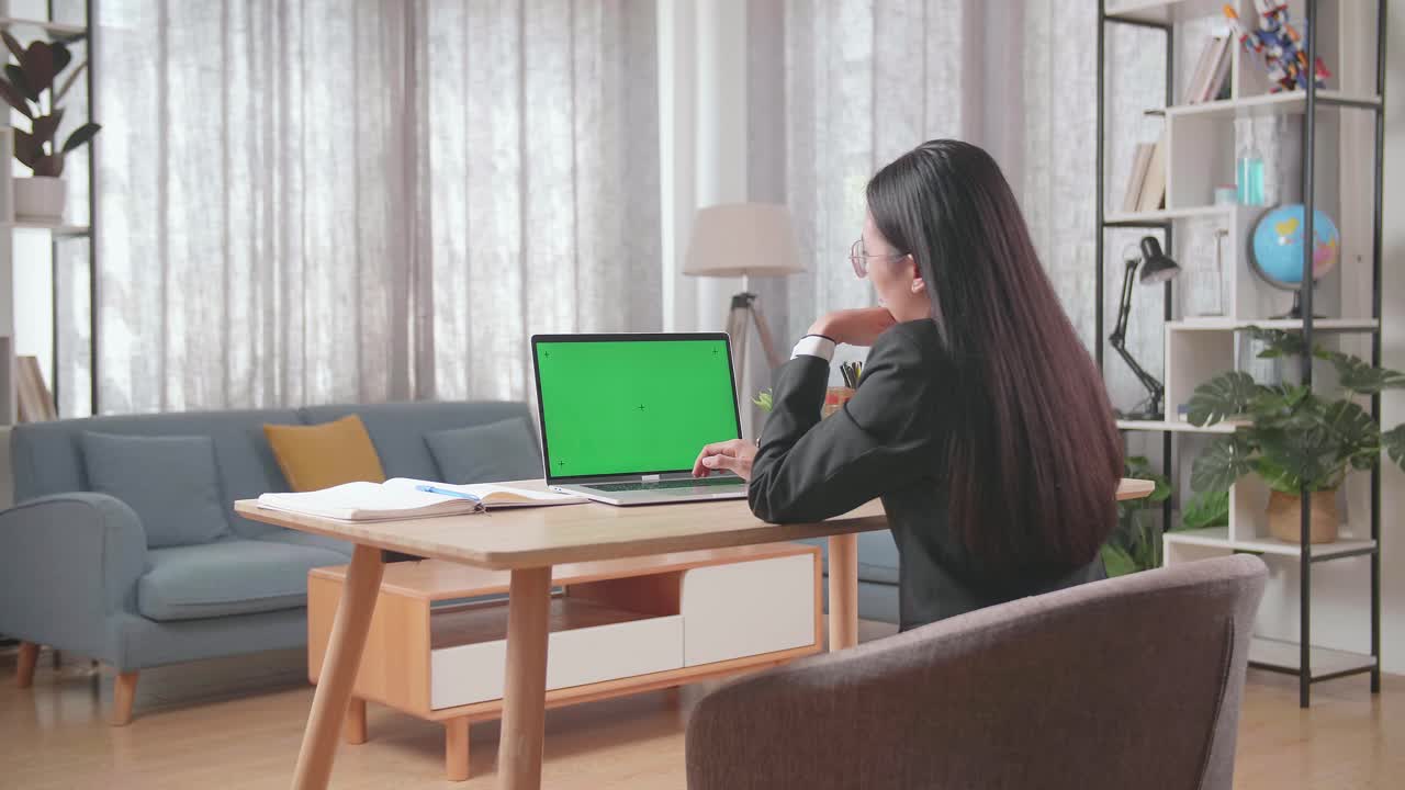 초록색 화면 을 가진 노트북 에서 집 에서 일 하는 여자