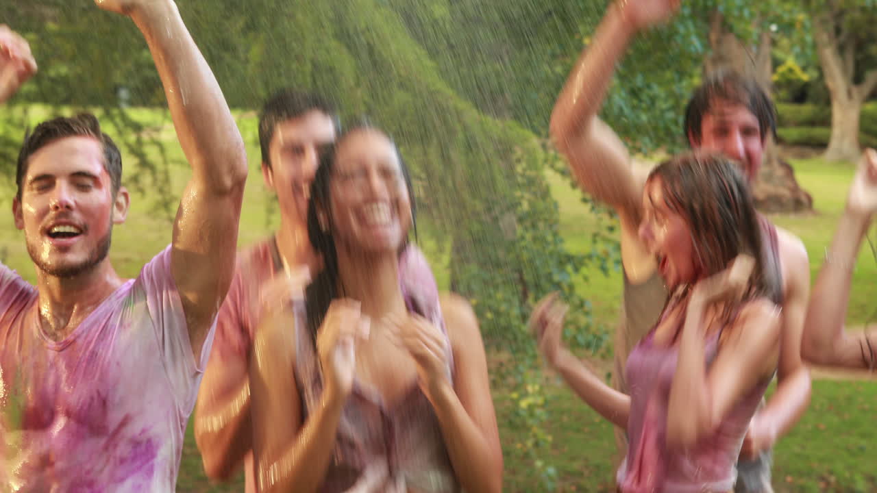 Amigos felizes se divertindo com mangueira no parque