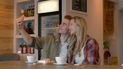 young couple taking selfie on mobile phone in cafe 4k