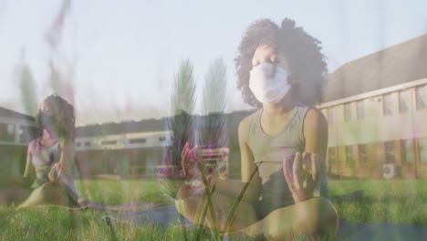 animation of flowers over diverse children with face masks practicing yoga and meditating