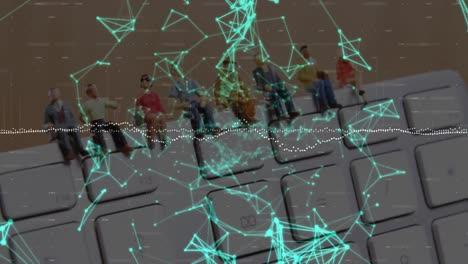 Animation-of-network-of-connections-over-people-figurines-on-computer-keyboard