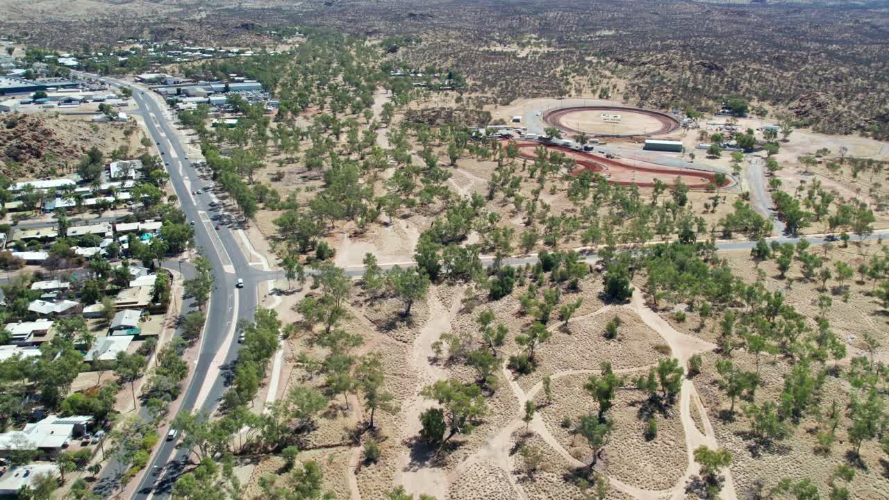 Aerial view along the Stuart Highway and the Arunga Park Speedway, north of Alice Springs, Mparntwe, Northern Territory, Australia. August 2022.