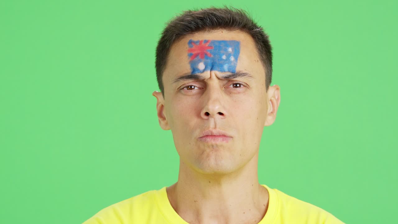 Serious man with a australian flag painted on the face