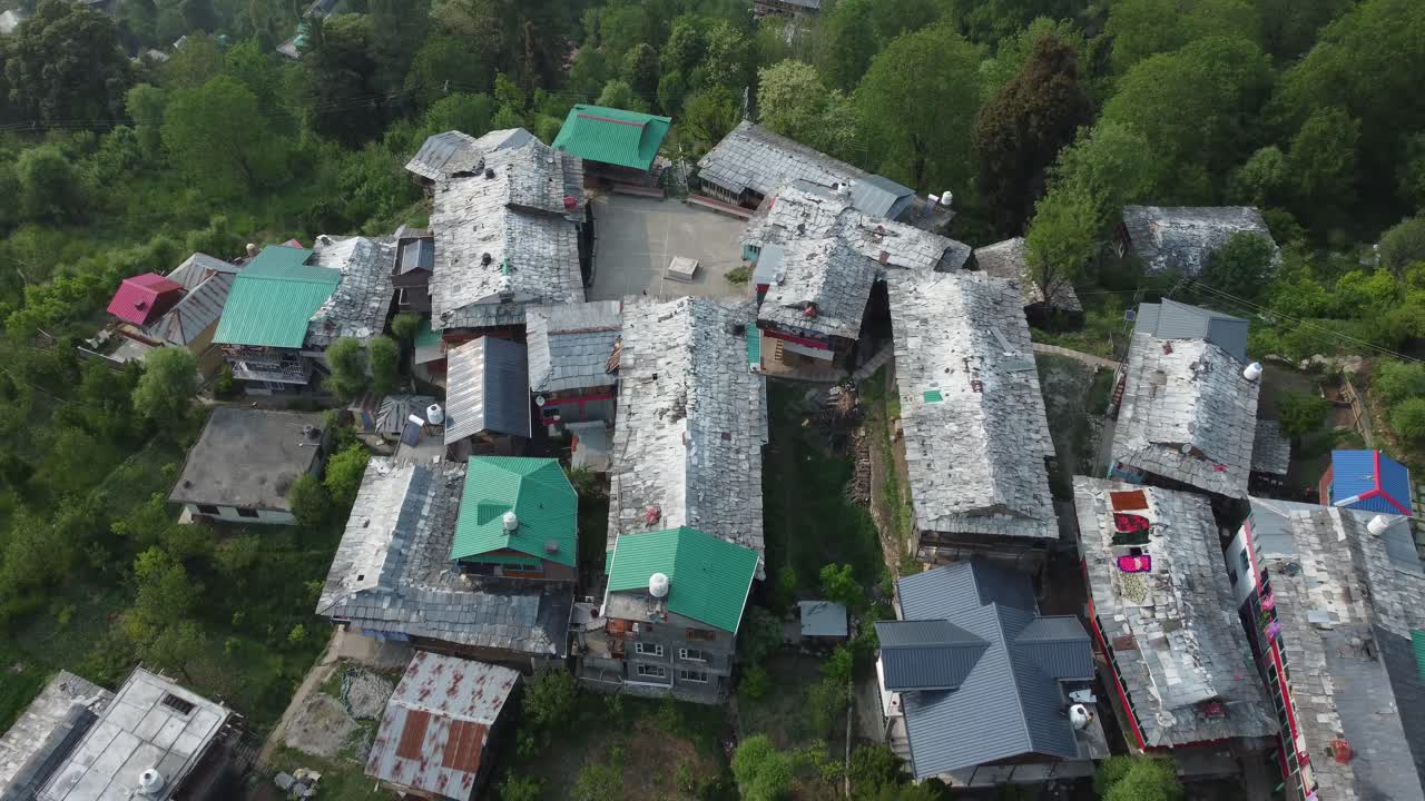 Hindistan'daki Jibhi Himachal Pradesh'in yakınından kuşbakışı görünüm. Dağlık bölgede evler ve ağaçlar. Faguli festivali, Jibhi'deki en büyük festivallerden biridir. Buradaki geleneksel evlerin taş çatıları bulunmaktadır.