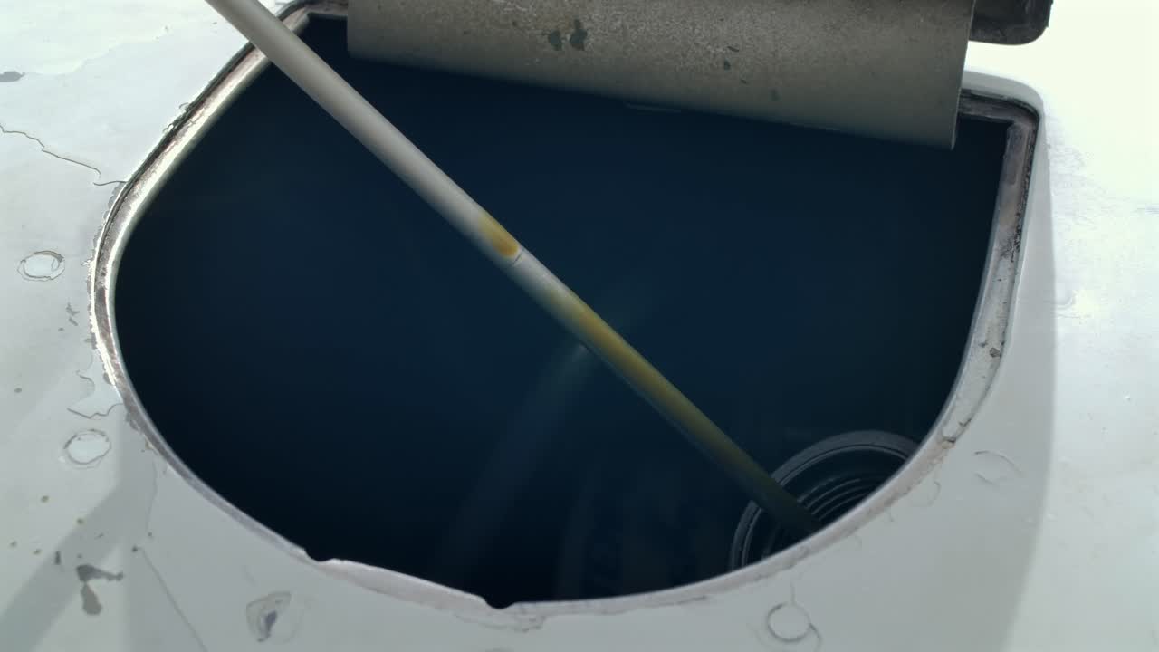 Inserting Dipstick Into Tank, Checking Oil Fluid Level Of A Vehicle. Close Up Shot