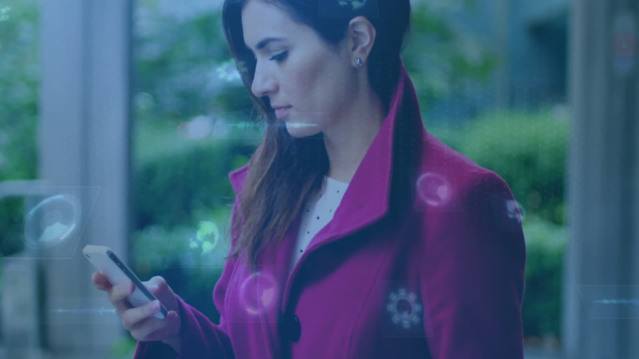 Using smartphone with digital animation, woman in red coat in school hallway