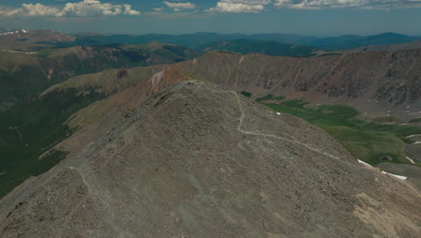 Aerial-cinematic-drone-early-morning-people-hiking-trail-Grays-and-Torreys-14er-Peaks-flight-above-Rocky-Mountains-Continental-Divide-Colorado-stunning-landscape-summer-snow-circling-left-motion