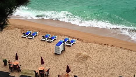 Aerial-view-of-tables-on-beach-with-sun-lounger