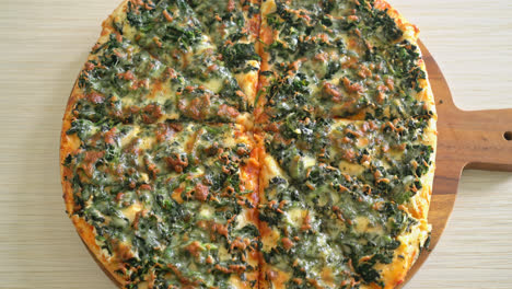 Pizza de espinacas y queso en bandeja de madera - estilo de comida vegetariana y vegana