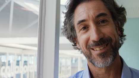 Portrait-of-man-smiling-in-a-creative-office