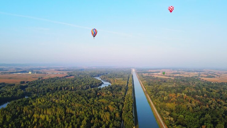 Varmluftsballoner over kanal- og flodlandskab
