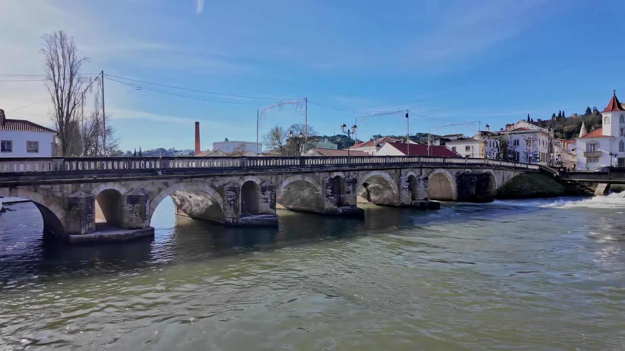 Fiume panoramico e ponte storico a Tomar, Portogallo, sotto un cielo azzurro