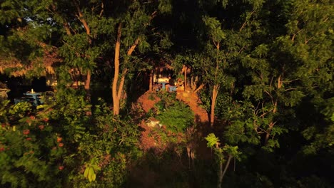 young man sitting at a table on his patio deep within a hillside rainforest