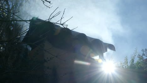 Chimenea-De-Barbacoa-Humeante-Con-Luz-Solar-Asomando-Desde-Atrás