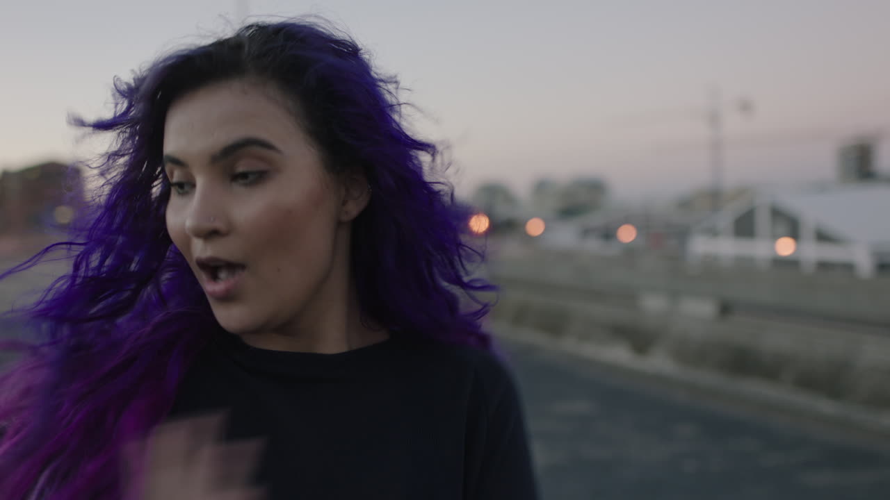 bailarina hermosa bailarina de calle con cabello colorido realizando movimientos contemporáneos de hip hop disfrutando de la expresión de danza moderna en la ciudad al atardecer