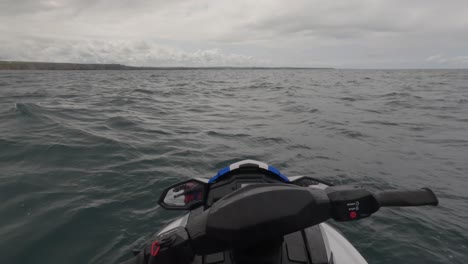 POV-Aufnahme-Eines-Jetski-Fahrers,-Der-In-Unruhigen-Wellen-Auf-Dem-Meer-Schwimmt-Und-Die-Küste-Von-Newquay-Betrachtet