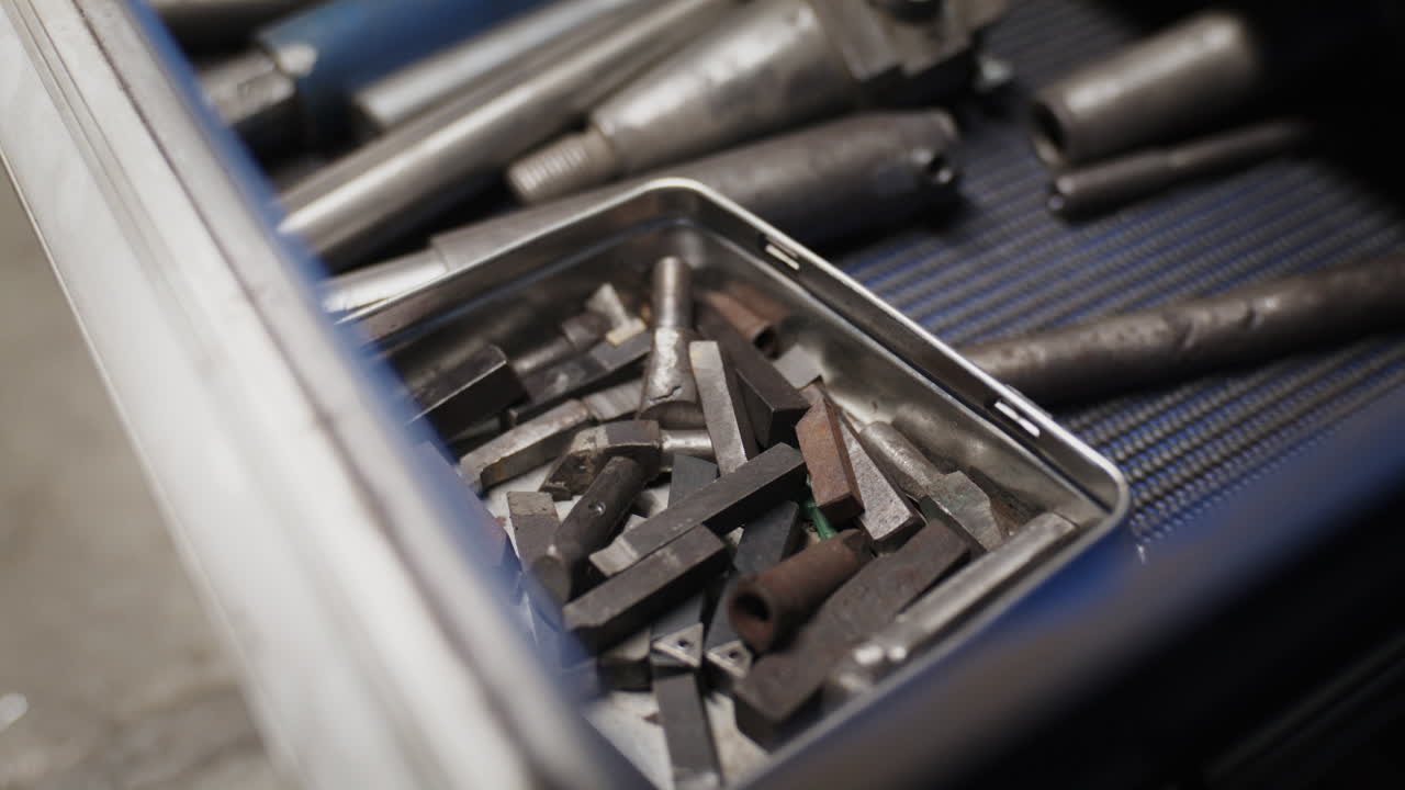 Close-up of a workshop drawer with industrial carbide drill bits and lathe tools