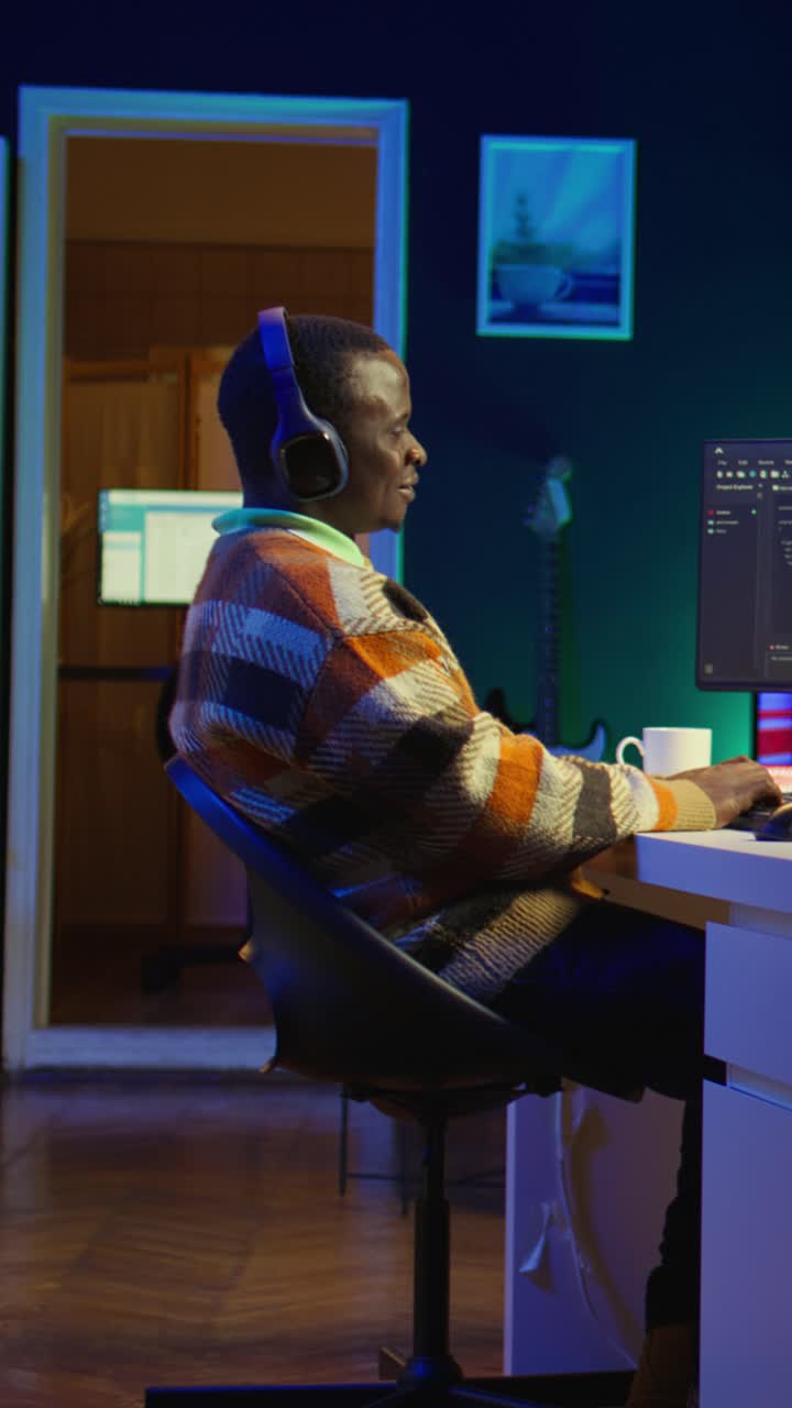 Vertical Video Black programmer remotely working in home office writing code on computer