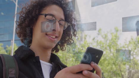 animación de pantallas digitales con procesamiento de datos sobre hombre biracial usando teléfono inteligente.