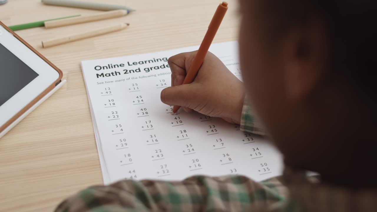 Child Doing 2nd Grade Math Worksheet