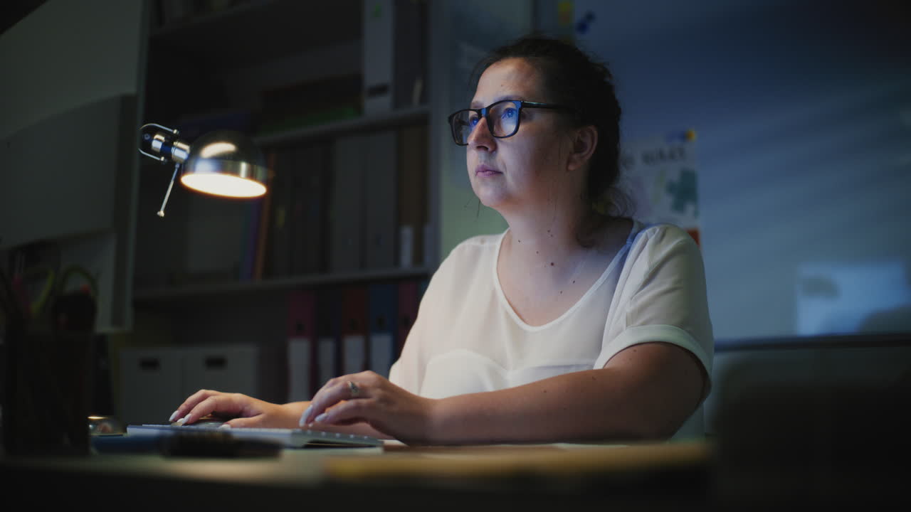 Elementary School Teacher Working on Computer at Night Checking Homework