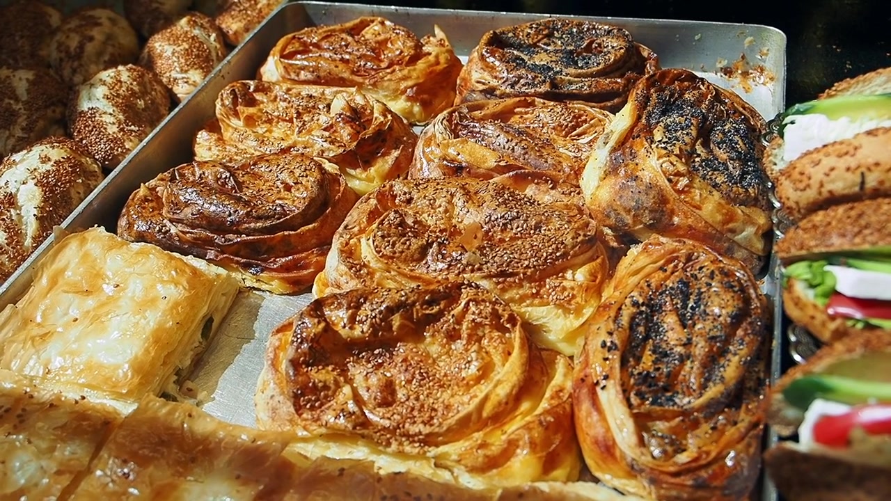 Primo piano di pasticcini dorati appena sfornati e panini freschi