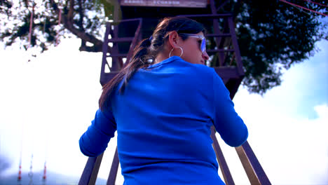 woman in blue clothes climbing the stairs