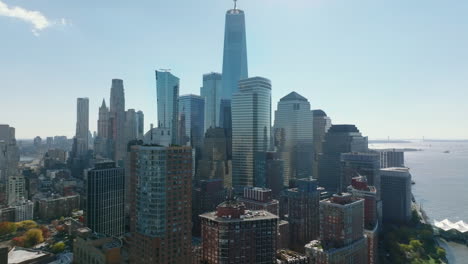 Backwards-reveal-of-group-of-apartment-buildings-in-Battery-Park-City-on-Hudson-river-waterfront.-Tall-skyscrapers-in-background.-Manhattan,-New-York-City,-USA