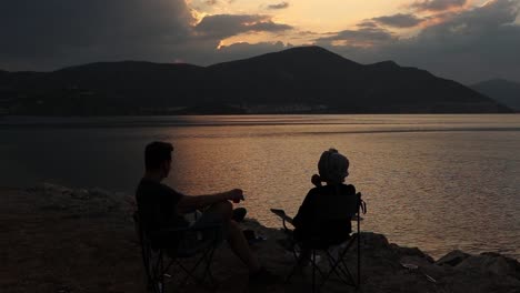 Pareja-Joven,-Sentado,-En-La-Playa