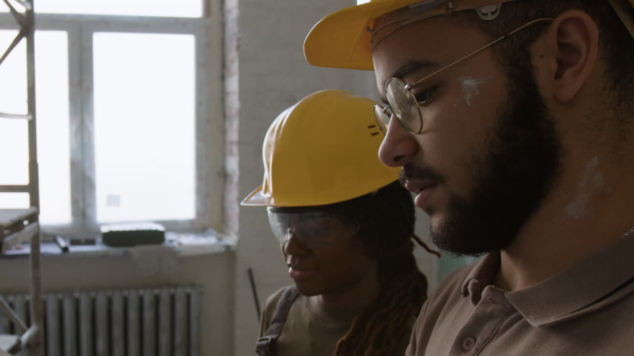 Construction workers reviewing blueprints on a construction site