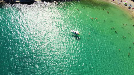 Bird's-Eye-View-Of-Tourists-On-The-Summer-Beach-Of-Prapratno-In-Croatia---aerial-drone-shot