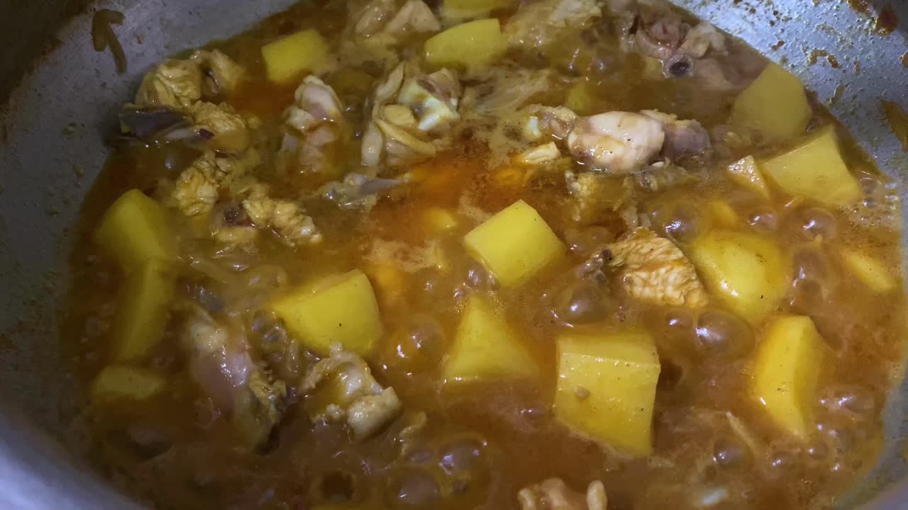 sabroso curry con pollo y papas cocinando