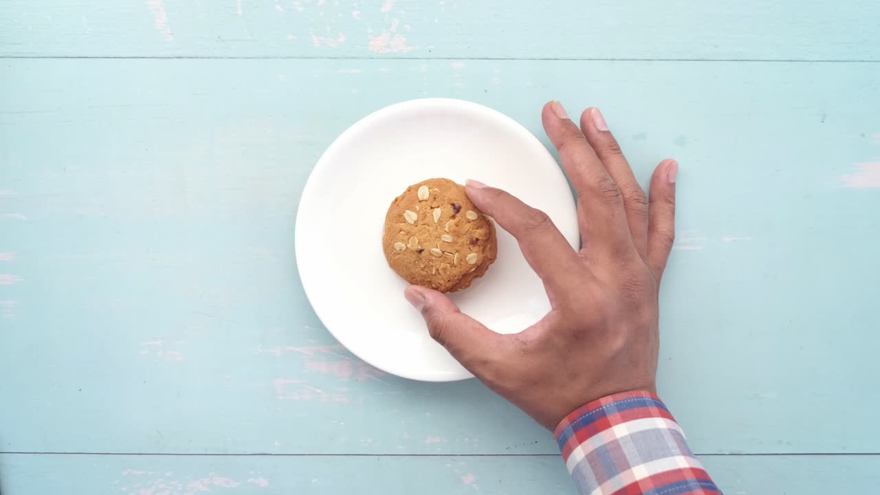 mano alcanzando una galleta en un plato