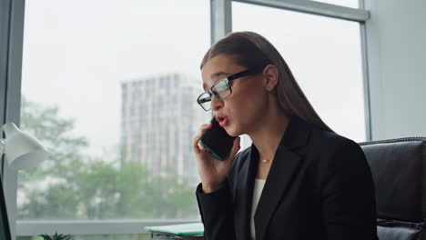 desperate businesswoman talk phone in office closeup. worried manager complain