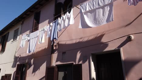 Secado-De-Ropa-A-Lo-Largo-De-La-Fachada-De-Un-Edificio-En-El-Pueblo-Medieval-De-Borghetto-Di-Ostia,-En-Las-Afueras-De-Roma