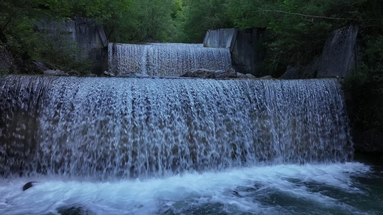 A static image capturing a beautiful waterfall near Lake Walensee in the region of Weesen, Switzerland, amidst dense jungle