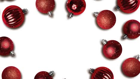 animation of snow falling over red christmas baubles decorations with copy space